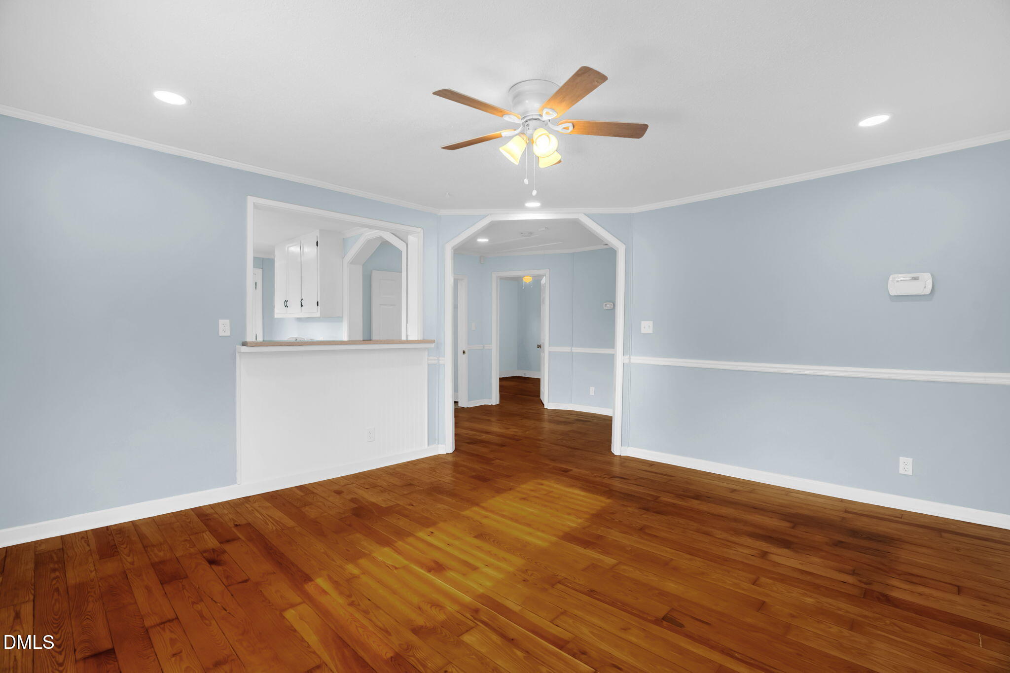 2807 Beck Road Durham, NC 27704 - Photo 6 of 35 a view of an empty room with wooden floor and a ceiling fan