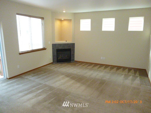 4120 150th Street Southeast Bothell, WA 98012 - Photo 3 of 16 a view of an empty room with wooden floor and a window