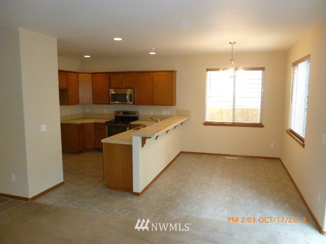 4120 150th Street Southeast Bothell, WA 98012 - Photo 4 of 16 a kitchen with stainless steel appliances granite countertop a stove a sink and a refrigerator