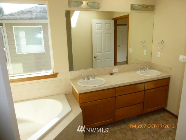 4120 150th Street Southeast Bothell, WA 98012 - Photo 10 of 16 a bathroom with a tub sink and mirror