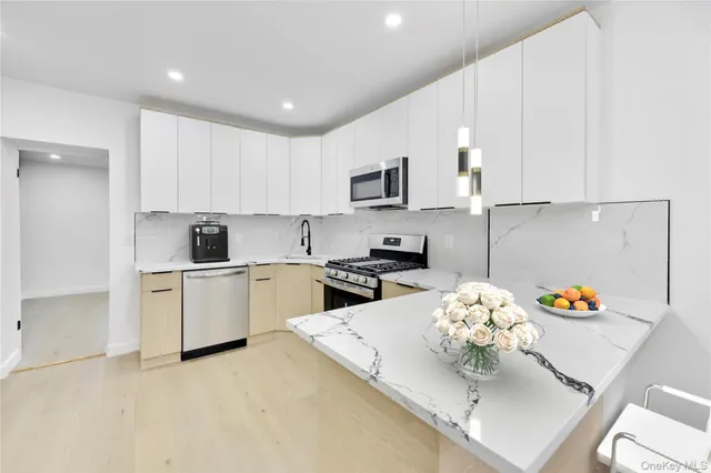 a kitchen with stainless steel appliances a stove a sink a microwave a refrigerator and cabinets