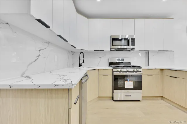 a kitchen with stainless steel appliances granite countertop a sink and a stove