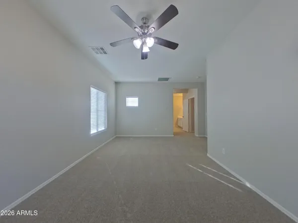 an empty room with windows and fan