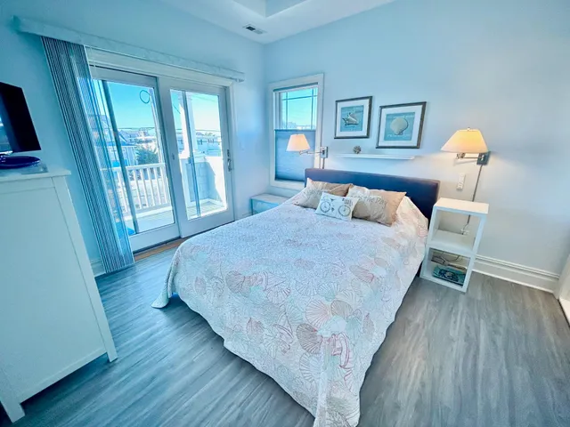 a bedroom with a bed and a flat tv screen on a dresser