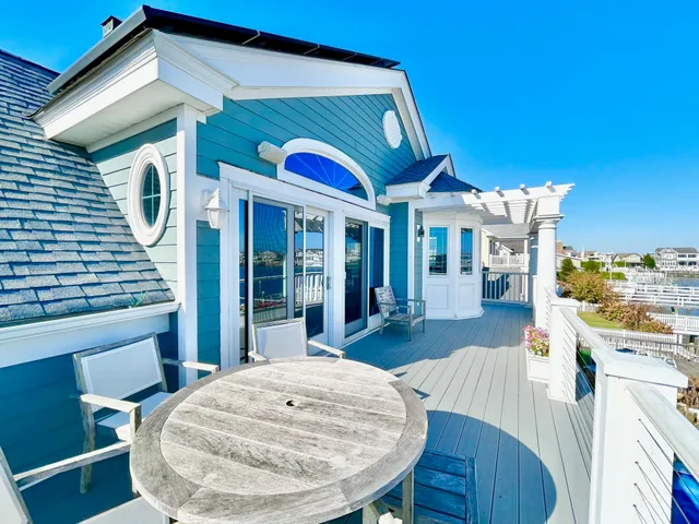 a view of a rooftop deck with couch and chairs
