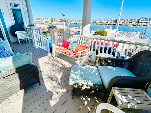 a view of a rooftop deck with couch and chairs
