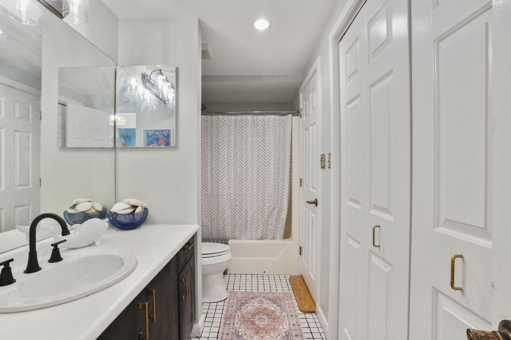 1 Commodore Court, Unit 104 Hull, MA 02045 - Photo 22 of 35 a bathroom with a sink and mirror