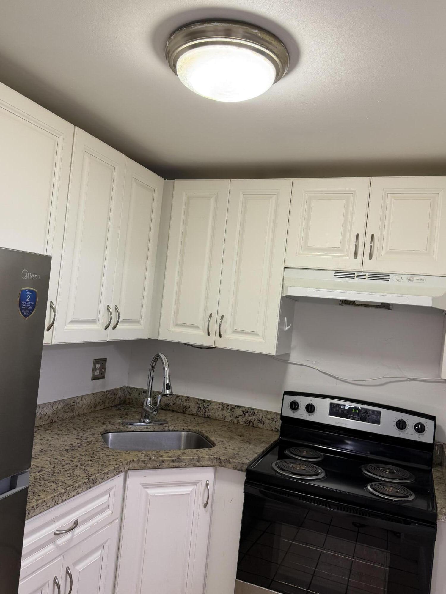 270 South Cypress Road, Unit 204 Pompano Beach, FL 33060 - Photo 2 of 14 a kitchen with granite countertop a stove sink and cabinets