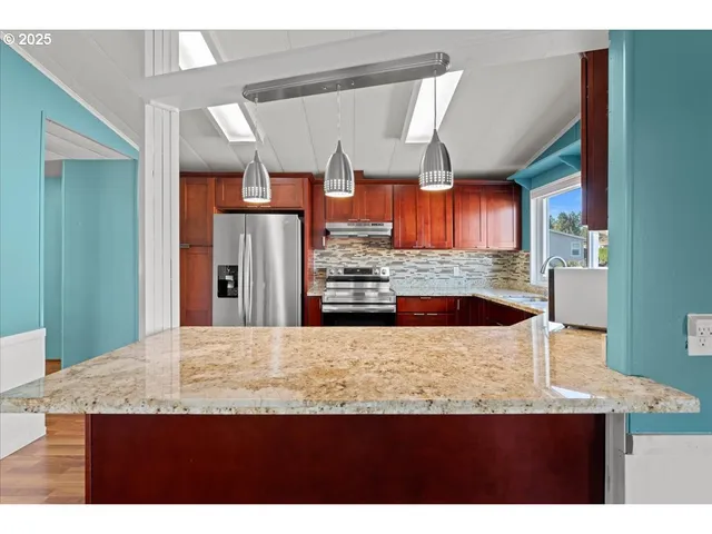 a kitchen with stainless steel appliances granite countertop wooden cabinets stove top oven and sink