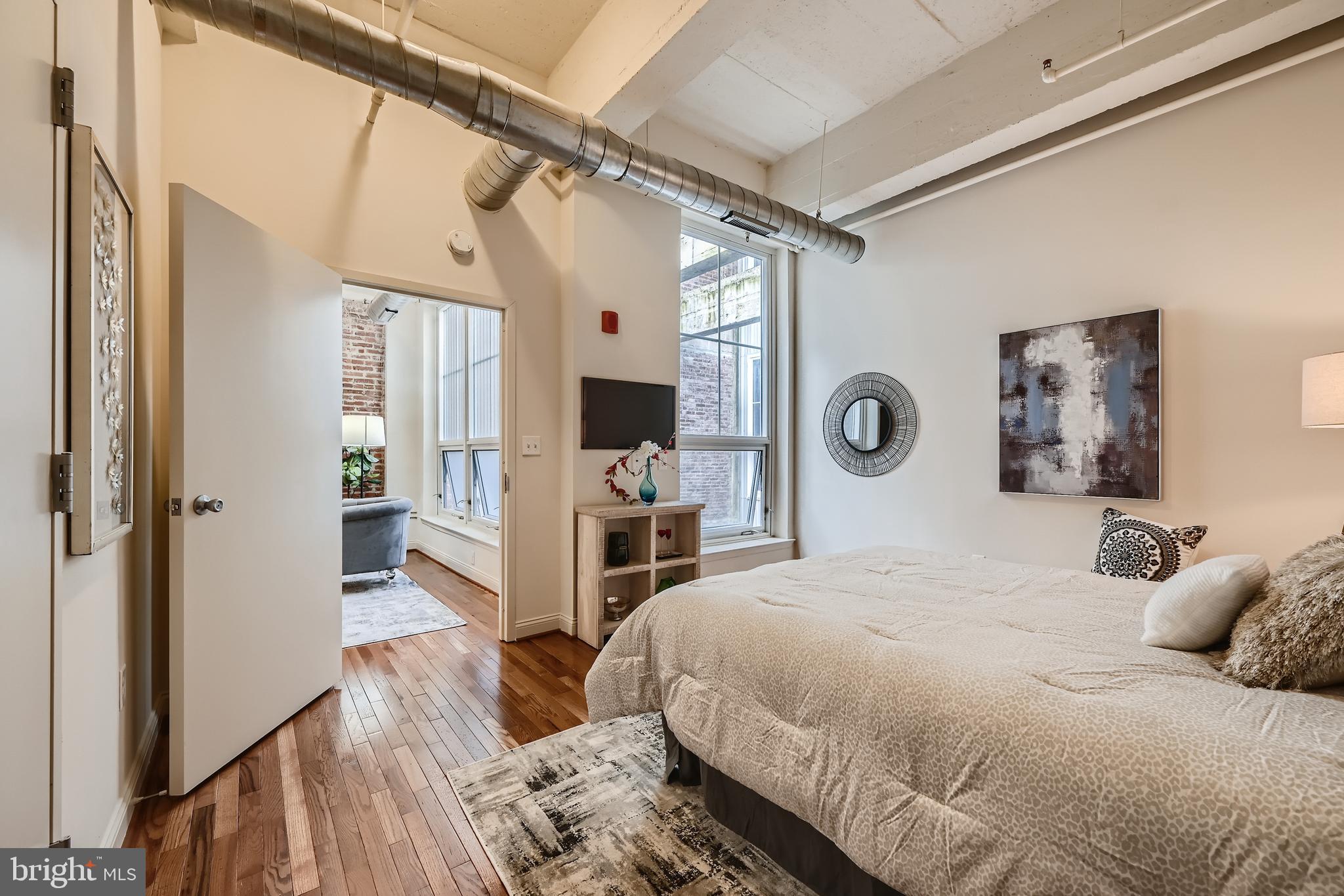 311 West Baltimore Street, Unit 503 Baltimore, MD 21201 - Photo 8 of 29 a bedroom with a large bed and a flat tv screen