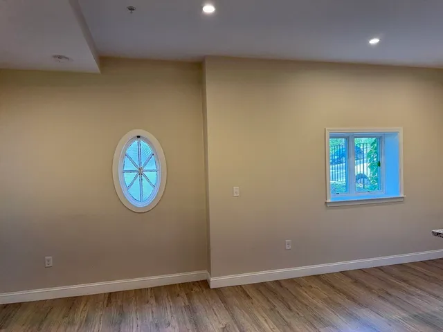 an empty room with a wooden floor and a window