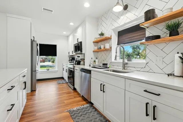 a bathroom with a sink a mirror and a potted plant