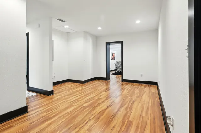 a front view of a house with a garden and trees