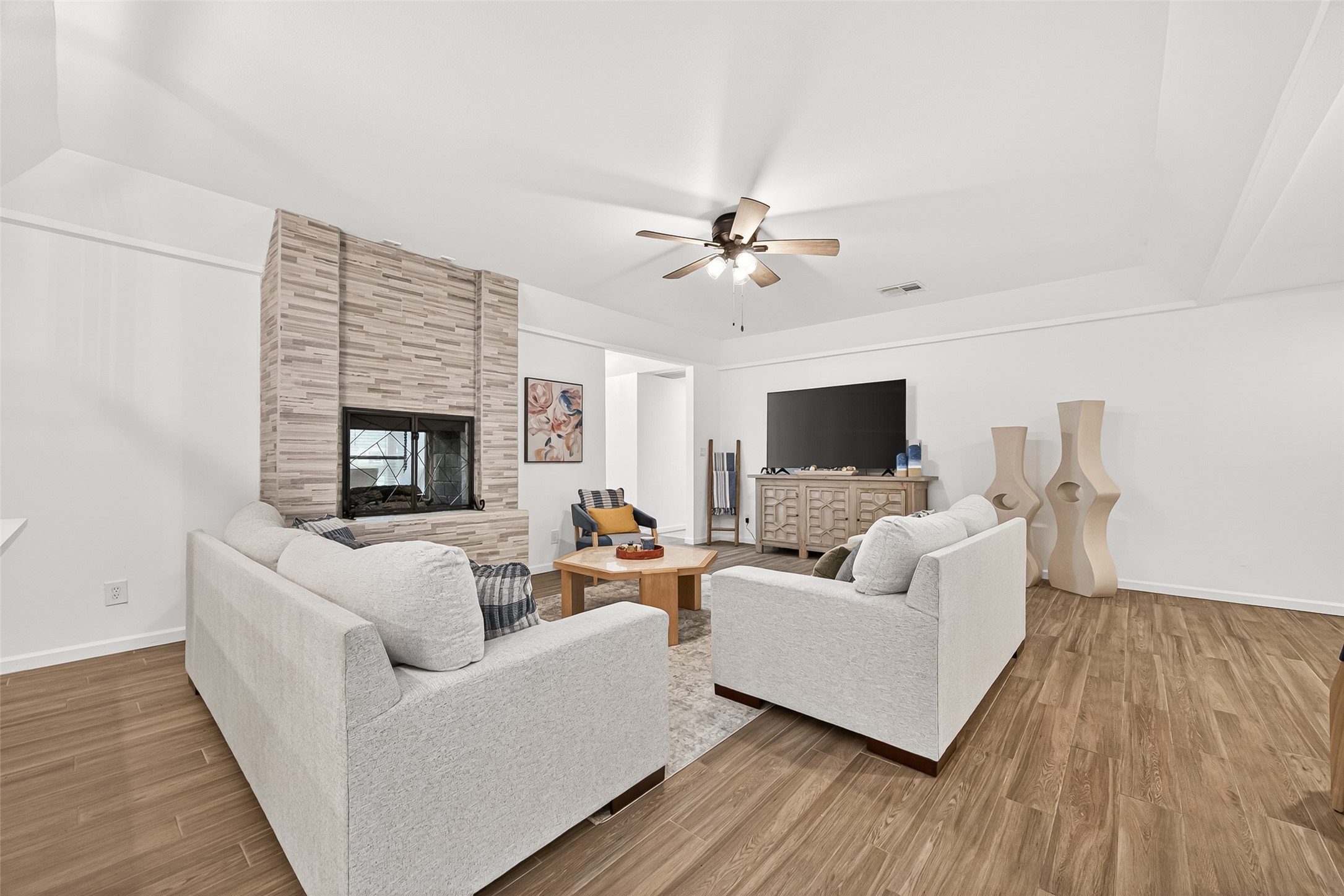 548 Brandon Road Conroe, TX 77302 - Photo 5 of 37 Bright and inviting open concept living room featuring wood like tile flooring, abundant windows for natural light and furnished in modern tones that create a warm and welcoming atmosphere.