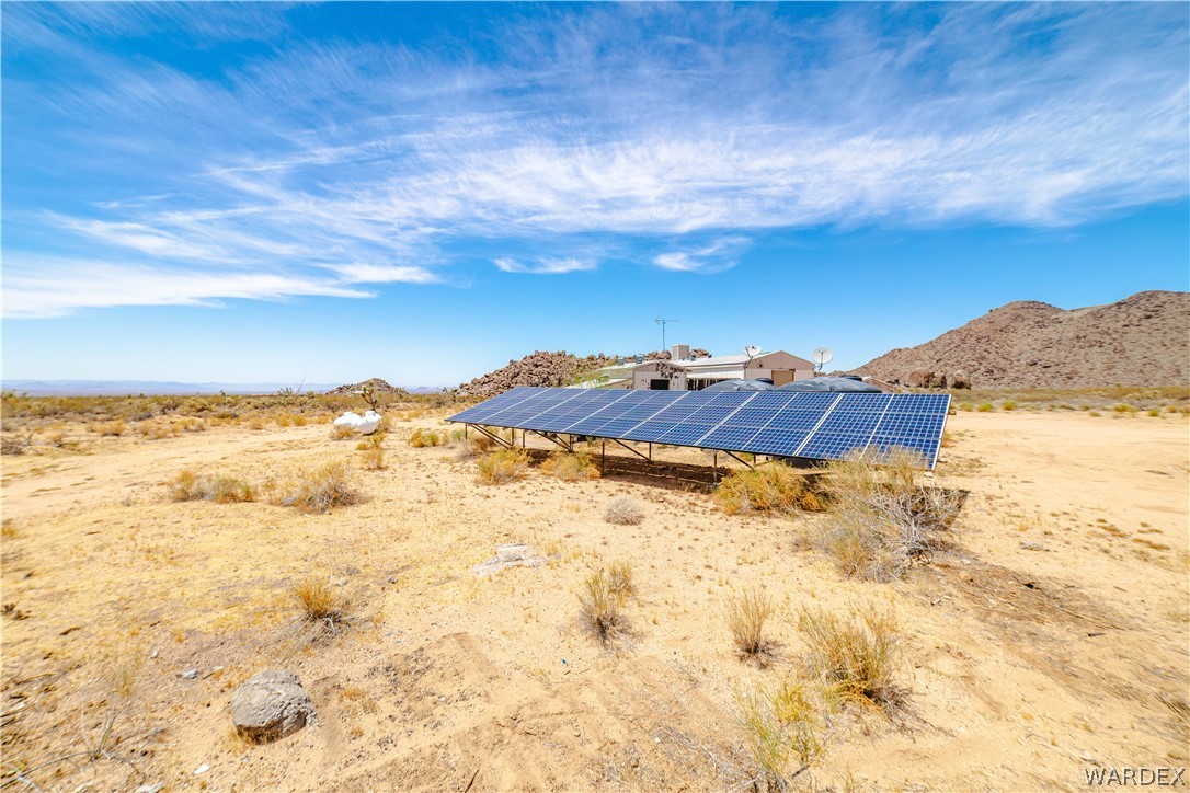 16435 South Wyatt Earp Road Yucca, AZ 86438 - Photo 29 of 57 Ground-mounted solar panel array situated on a desert landscape with natural rock formations