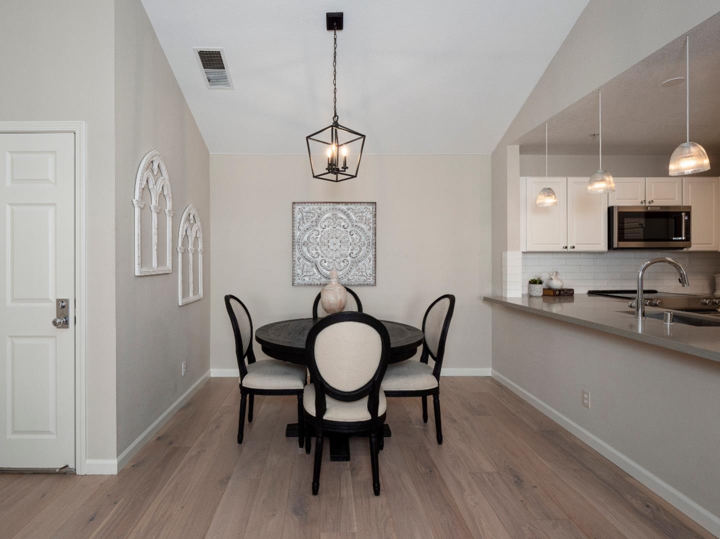935 Old County Road, Unit 45 Belmont, CA 94002 - Photo 4 of 18 a dining room with wooden floor a chandelier a wooden table and chairs