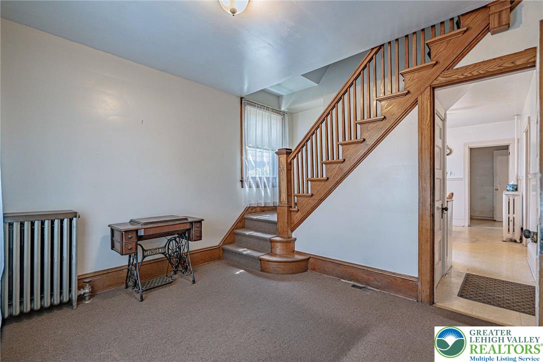 159 West Ridge Street Nesquehoning, PA 18240 - Photo 6 of 55 A grand wooden staircase with intricate banisters defines the entry space.