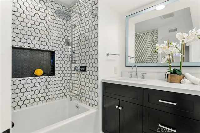 a bathroom with a bathtub sink vanity mirror and shower