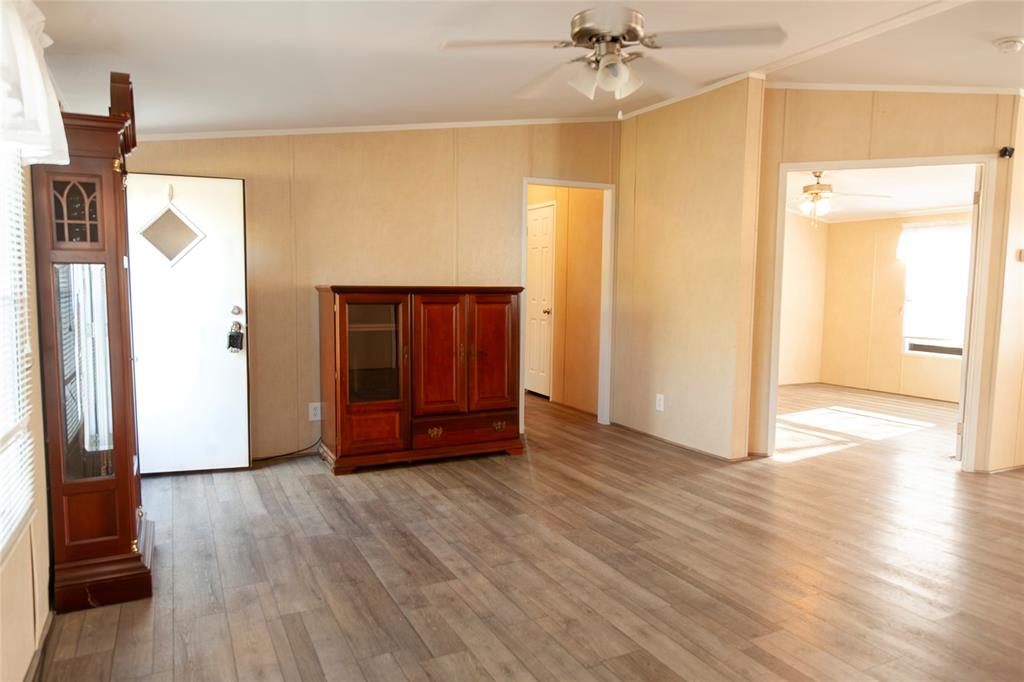 112 Southeast Front Street, Unit A Bailey, TX 75452 - Photo 17 of 39 Unfurnished living room featuring ornamental molding, light wood-style floors, and a ceiling fan