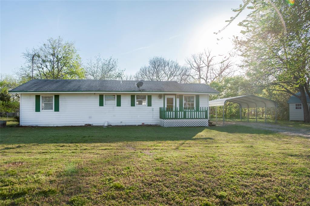 112 Southeast Front Street, Unit A Bailey, TX 75452 - Photo 2 of 39 Rear view of house featuring a lawn, a carport, and a wooden deck