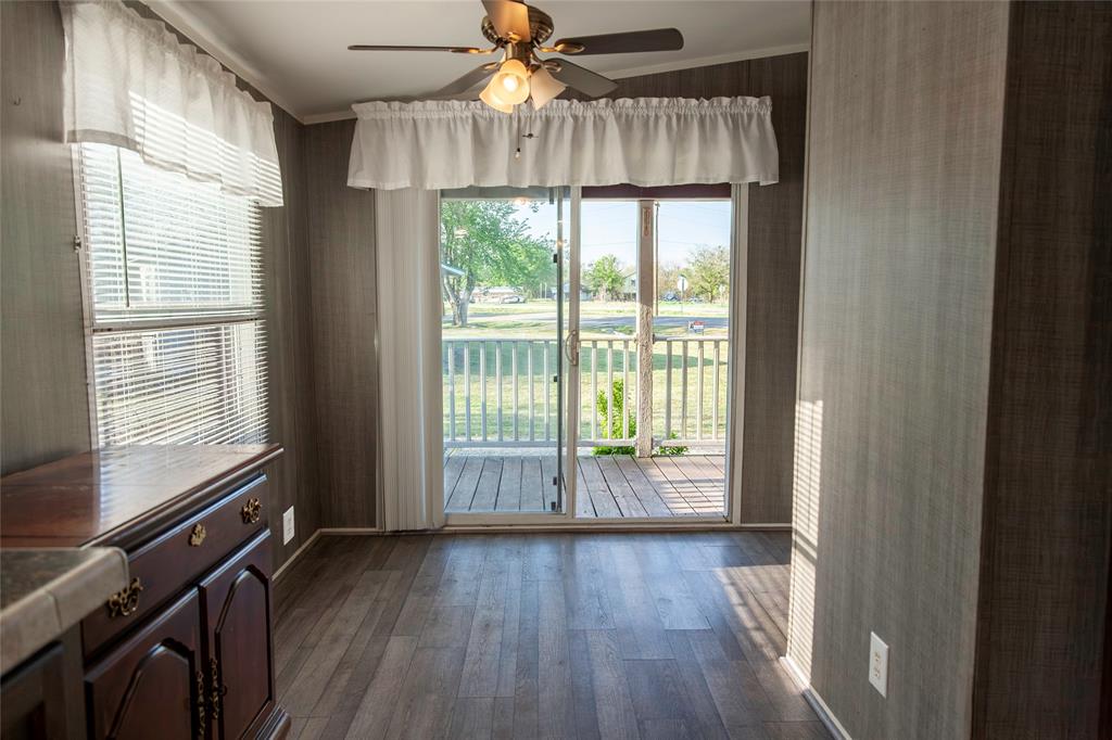 112 Southeast Front Street, Unit A Bailey, TX 75452 - Photo 25 of 39 Unfurnished dining area featuring ceiling fan, wallpapered walls, and dark wood-style floors