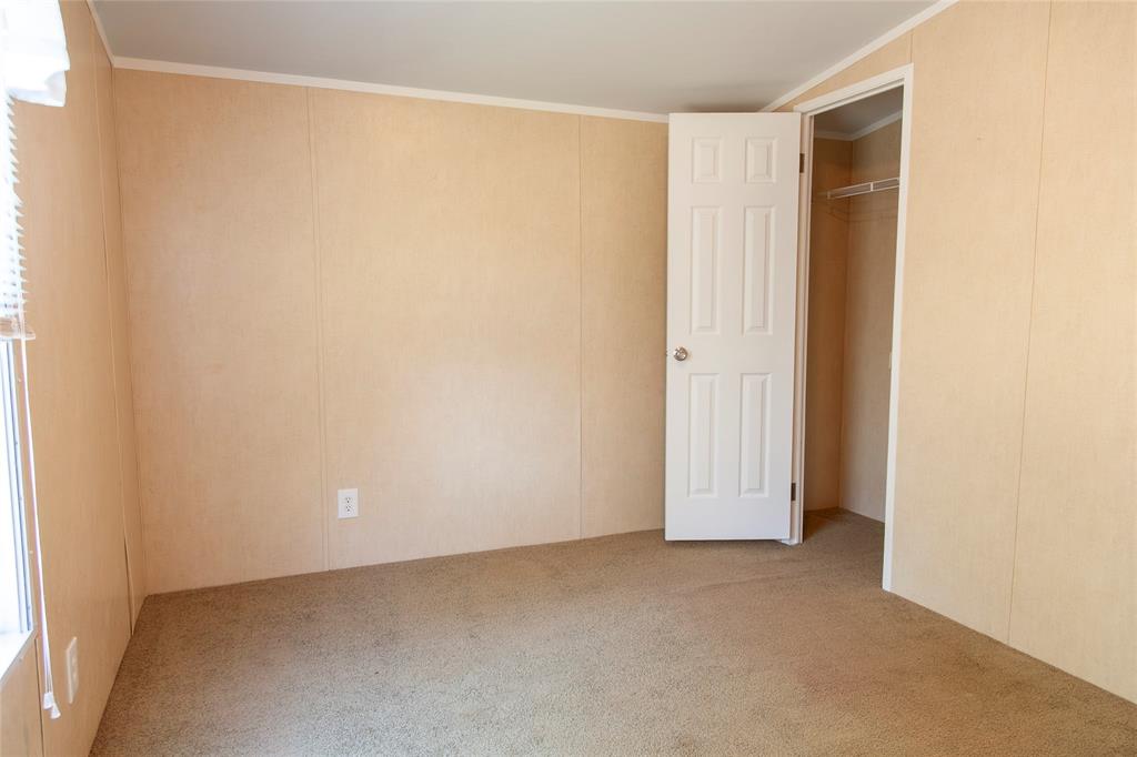 112 Southeast Front Street, Unit A Bailey, TX 75452 - Photo 27 of 39 Unfurnished bedroom featuring carpet, a decorative wall, a closet, and ornamental molding
