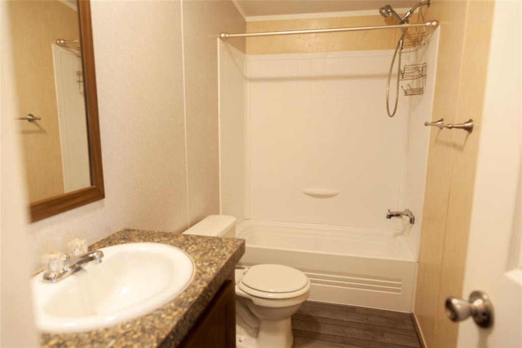 112 Southeast Front Street, Unit A Bailey, TX 75452 - Photo 28 of 39 Bathroom with vanity, tub / shower combination, and dark wood-style flooring
