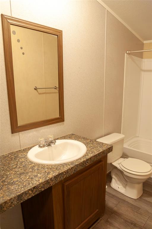 112 Southeast Front Street, Unit A Bailey, TX 75452 - Photo 29 of 39 Bathroom with vanity, bathtub / shower combination, wood finished floors, and crown molding
