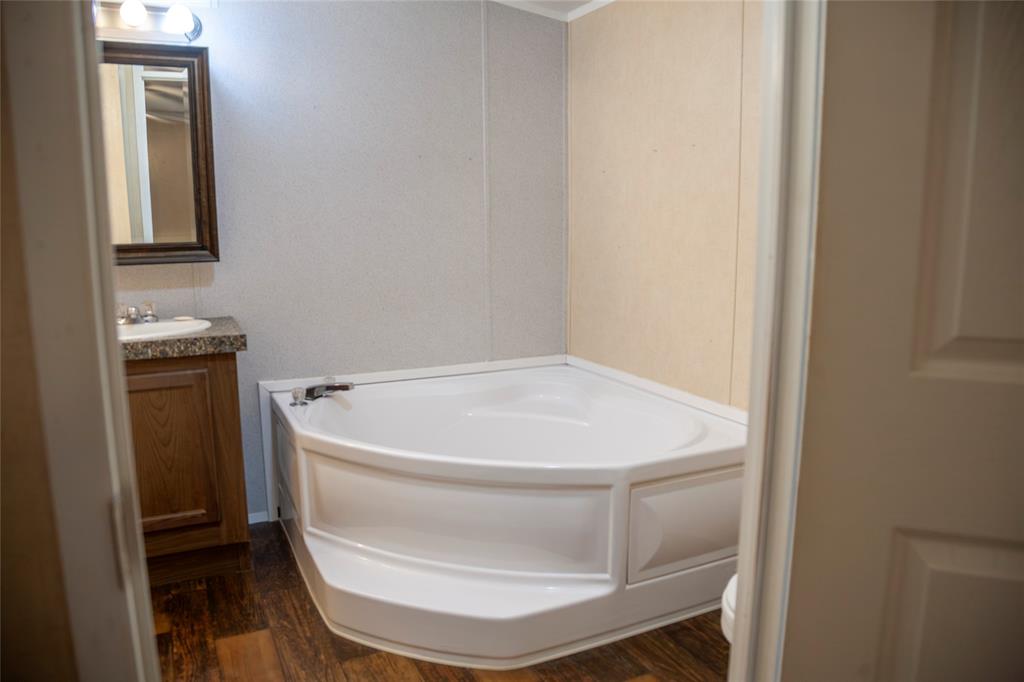 112 Southeast Front Street, Unit A Bailey, TX 75452 - Photo 34 of 39 Full bath featuring vanity, a garden tub, and dark wood-type flooring