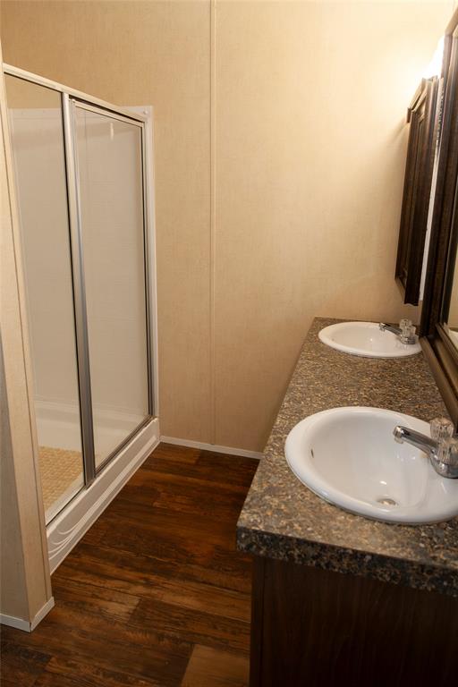 112 Southeast Front Street, Unit A Bailey, TX 75452 - Photo 36 of 39 Bathroom with a shower stall, dark wood-style flooring, and double vanity