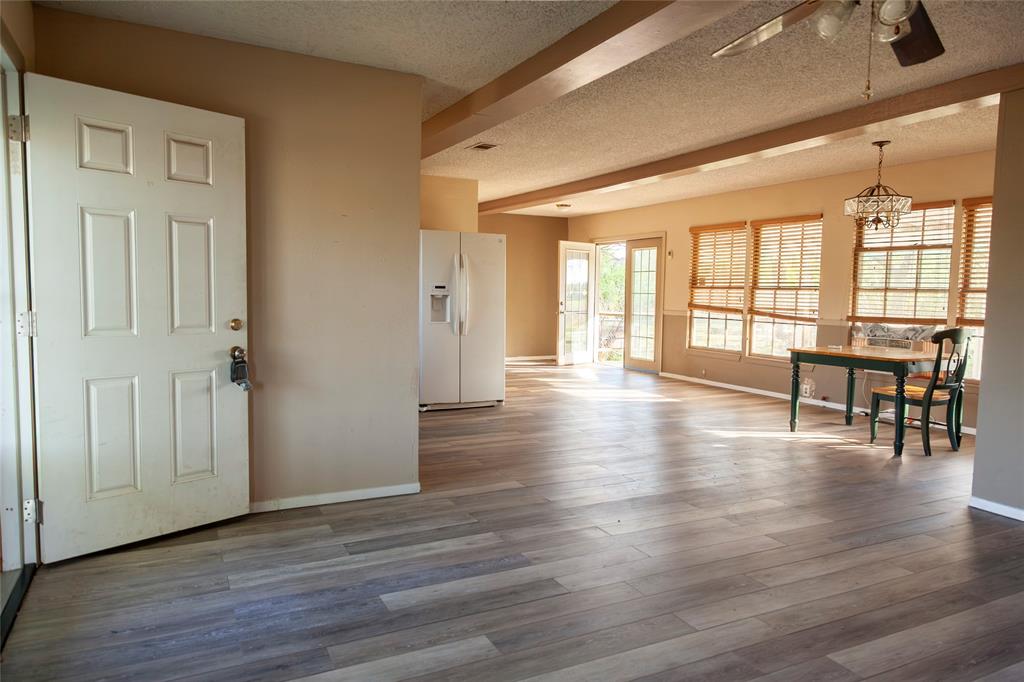 112 Southeast Front Street, Unit A Bailey, TX 75452 - Photo 4 of 39 Entrance foyer with a ceiling fan, dark wood-type flooring, beamed ceiling, a textured ceiling, and hanging lights