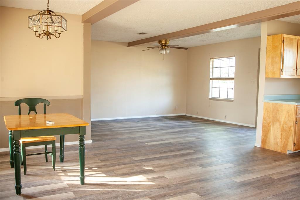 112 Southeast Front Street, Unit A Bailey, TX 75452 - Photo 5 of 39 Unfurnished dining area featuring beamed ceiling, a ceiling fan, light wood-type flooring, a chandelier, and a textured ceiling