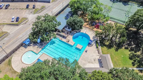 a view of swimming pool with lawn chairs and plants