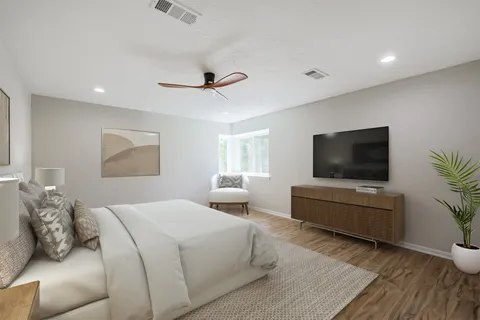 a bedroom with a bed and a flat screen tv
