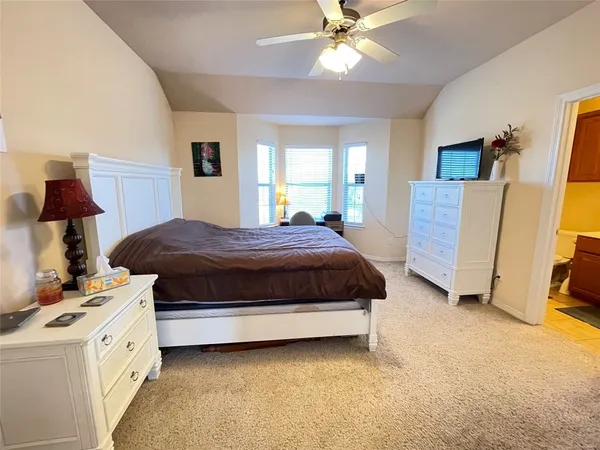 a bedroom with a bed and a lamp on the dresser