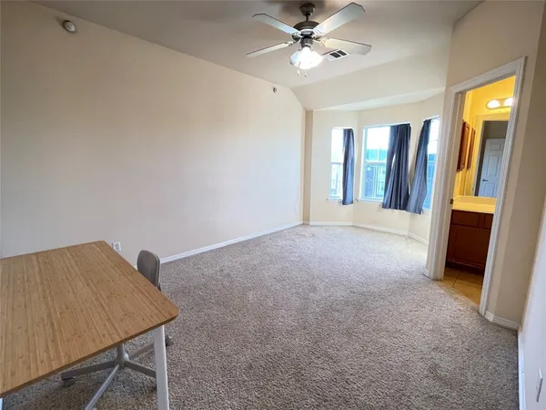 a view of a room with a ceiling fan and a rug