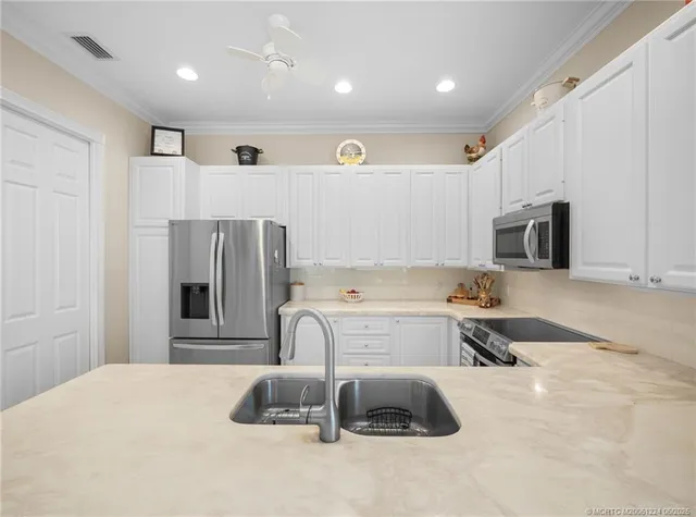 a kitchen with stainless steel appliances a refrigerator sink and microwave