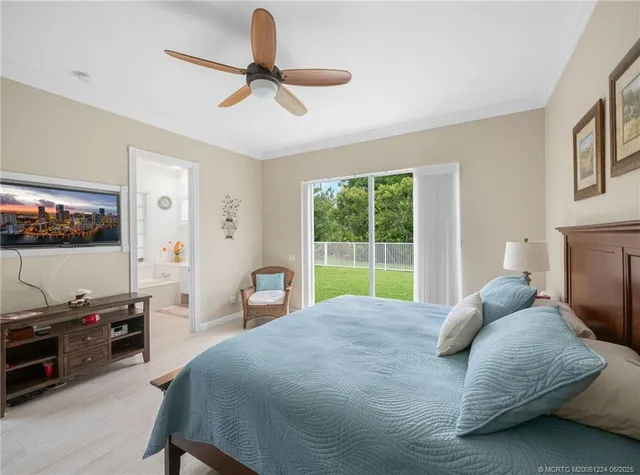 a bed room with a bed a television and a large window