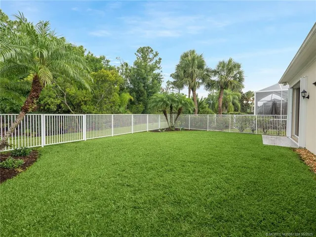 a view of a yard with a fence and trees
