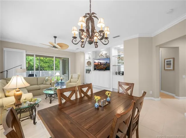 a view of a dining room with furniture a chandelier and wooden floor