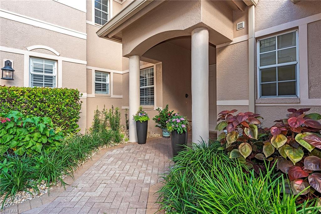 745 Regency Reserve Circle, Unit 5202 Naples, FL 34119 - Photo 2 of 14 a front view of a house with a yard