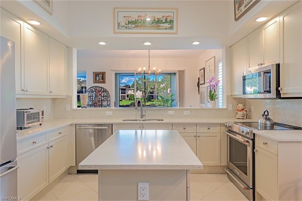 745 Regency Reserve Circle, Unit 5202 Naples, FL 34119 - Photo 5 of 14 a kitchen with a sink window and cabinets