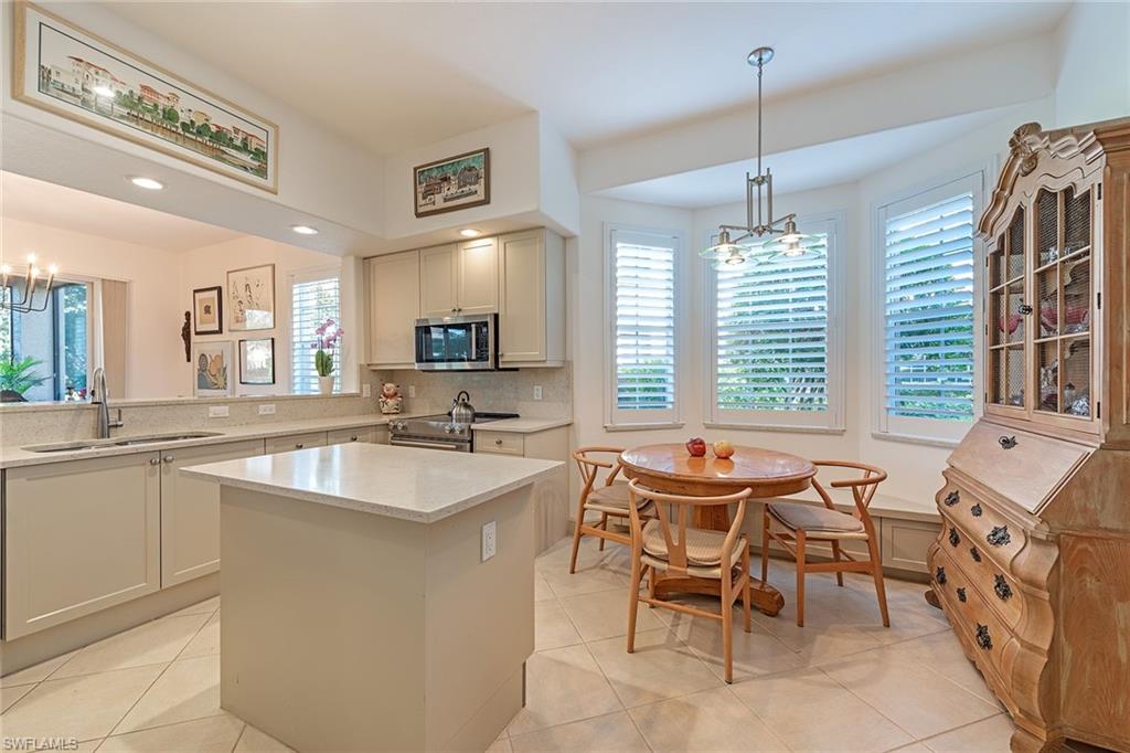 745 Regency Reserve Circle, Unit 5202 Naples, FL 34119 - Photo 6 of 14 a kitchen with stainless steel appliances granite countertop a sink and a stove