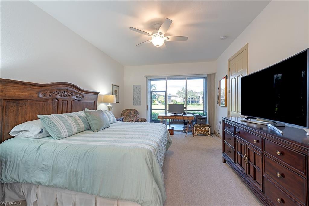 745 Regency Reserve Circle, Unit 5202 Naples, FL 34119 - Photo 7 of 14 a bedroom with a bed and a flat screen tv