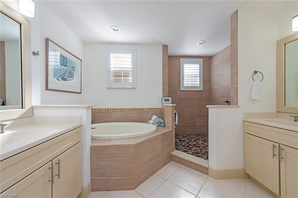 745 Regency Reserve Circle, Unit 5202 Naples, FL 34119 - Photo 8 of 14 a bathroom with a sink a bathtub and a window