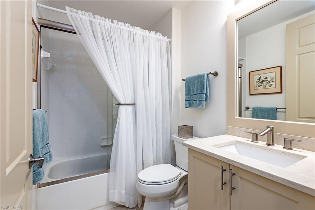 745 Regency Reserve Circle, Unit 5202 Naples, FL 34119 - Photo 10 of 14 a bathroom with a granite countertop sink toilet and shower