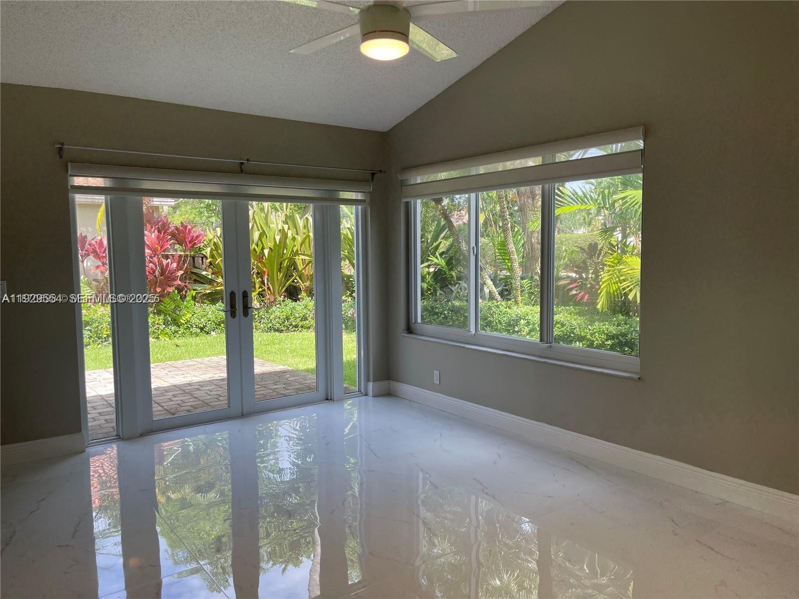 10101 Northwest 5th Street, Unit 10101 Plantation, FL 33324 - Photo 14 of 29 a view of an empty room with wooden floor and a window