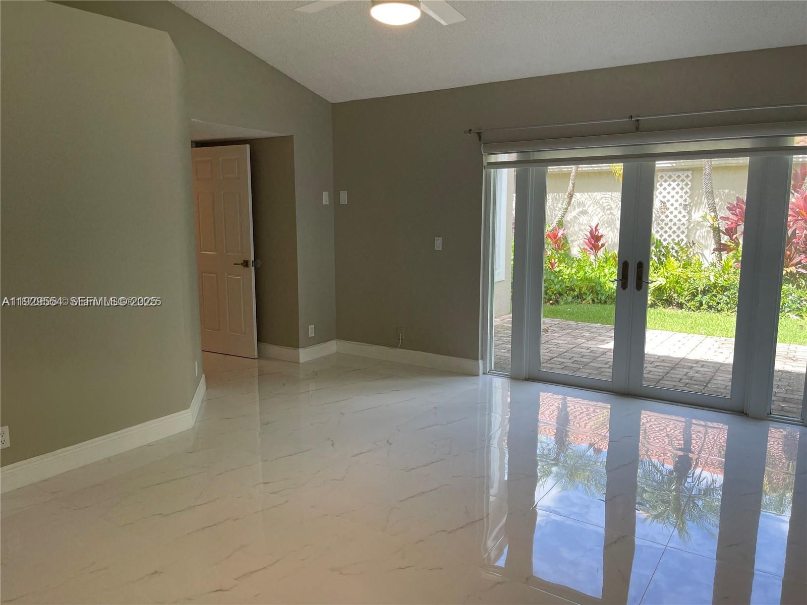 10101 Northwest 5th Street, Unit 10101 Plantation, FL 33324 - Photo 15 of 29 a view of an empty room with wooden floor and a window