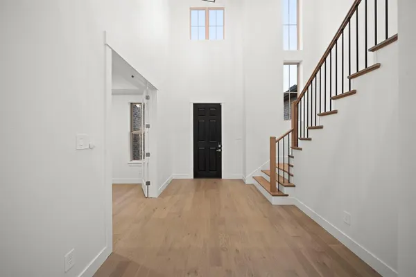 a view of a hallway with wooden floor and entryway