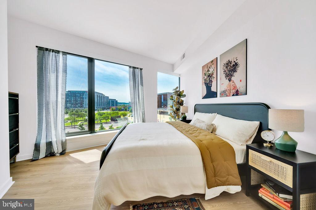 113 Potomac Avenue Southwest, Unit 1100 Washington, DC 20024 - Photo 12 of 50 a bed sitting in a bedroom next to a large window